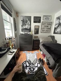 a person laying on the floor with their feet up in front of a bed and dresser