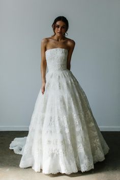 a woman in a white wedding dress posing for the camera with her hands on her hips