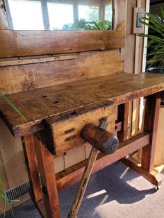 an old wooden workbench sitting in front of a potted plant and window