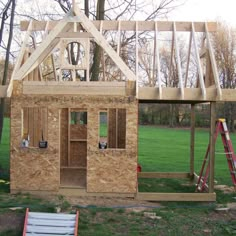 a house being built in the middle of a yard with wood framing on the roof