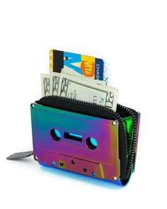 Are you a music lover? Fan of the 80s? Or just like useable works of art? Well, this wallet designed to look like an old school cassette tape (actual size!) appeases all of those needs. Cute, style, and purposeful. Durable, plastic wallet or stash pouch Zips open on 3 sides for ease Includes webbing for support Only vegan leather is used Shiny, chrome-plated cassette design Features boom box icon zip charm! Measurements: 4" x 2.5" x 1.5" By Fydelity Bags Cassette Design, Rainbow Chrome, Plastic Wallet, Retro Cassette, Box Icon, Boom Box, Festival Gear, Black Rainbow, Festival Accessories