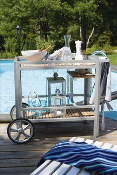 an outdoor table next to a swimming pool