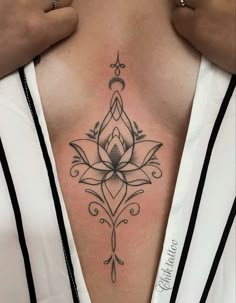 a woman's chest with a lotus tattoo on it, and the bottom part of her stomach