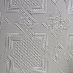 a close up view of an intricate white wallpaper