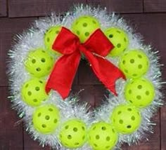 a christmas wreath with green balls and red bow