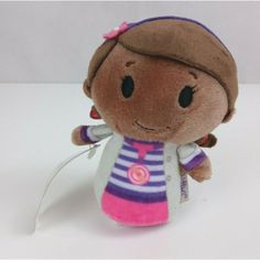 a small stuffed doll with a pink and blue striped shirt