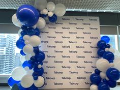 blue and white balloons are arranged in the shape of an arch