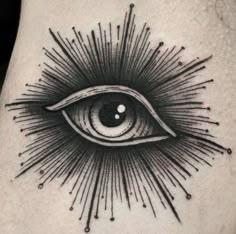 an all seeing eye tattoo on the side of a man's right leg with sun rays