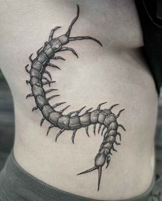 a black and white photo of a woman's stomach with a scorpion tattoo on it