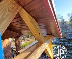 the underside of a wooden structure with wood slats on it and trees in the background