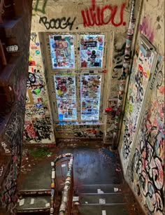 an abandoned building with graffiti all over the walls and stairs leading up to a window