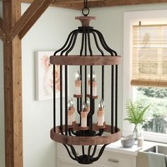 a chandelier hanging from a wooden beam in a room with white walls and windows