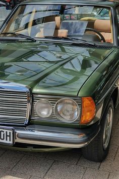 a green mercedes benz parked on the street