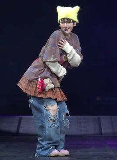 a person in a costume on stage with a stuffed animal on his shoulders and legs