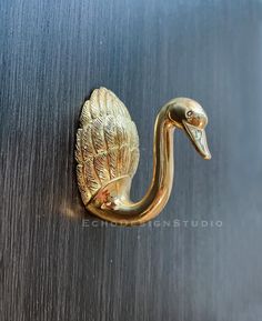 a metal door handle with a gold bird on it