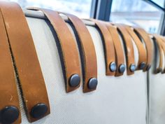 the back of a bus seat with leather straps