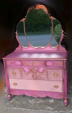 a pink dresser with a mirror on top of it