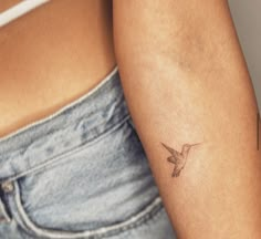 a small hummingbird tattoo on the left arm