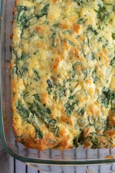 a casserole with spinach and cheese in a glass dish on a wire rack