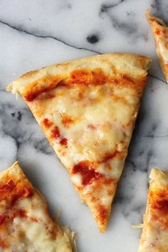 four slices of cheese pizza on a marble surface