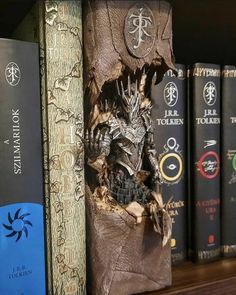 a book shelf with several books on it and a game of thrones statue next to them