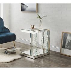 a glass side table with a blue chair in the background