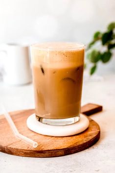 a cup of coffee sitting on top of a wooden coaster