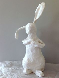 a white ceramic rabbit sitting on its hind legs