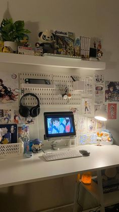 a white desk with a computer monitor and keyboard sitting on top of it next to a shelf