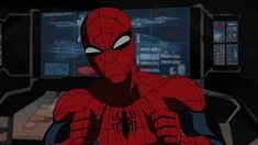 the spider - man is sitting in front of two computer monitors, with his hands on his chest