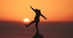 a person jumping in the air at sunset