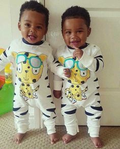 two young boys standing next to each other wearing pajamas with cartoon characters printed on them