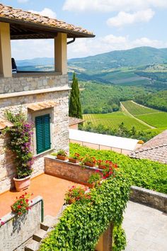 an outdoor area with flowers and greenery on the roof, surrounded by hills in the distance