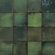 a green tiled wall with rusted metal grates