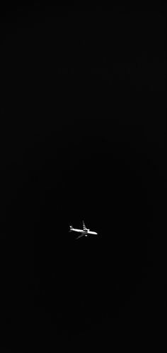 an airplane is flying in the dark sky