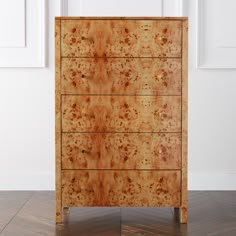 a wooden dresser sitting on top of a hard wood floor next to a white wall