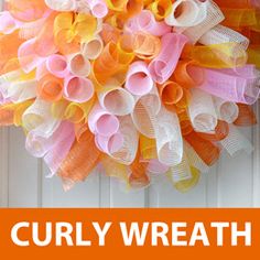 an orange and white wreath hanging on a door with the words curly wreath over it