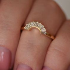 a woman's hand holding a diamond ring