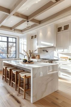 a large kitchen with white cabinets and marble counter tops, along with bar stools