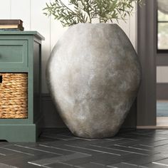 a large stone vase sitting on top of a tiled floor next to a small table