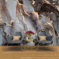 two chairs sitting next to each other in front of a marble wall