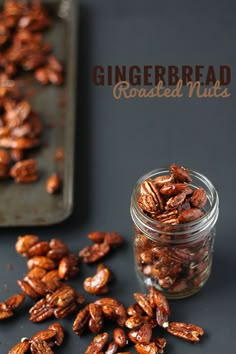 a jar filled with roasted nuts next to a cookie sheet