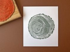 a piece of wood next to a rubber stamp with a tree ring design on it