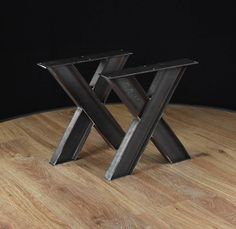 two metal legs sitting on top of a wooden table