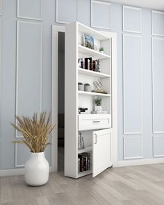 a tall white bookcase next to a vase filled with plants