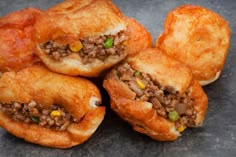 several pastries with meat and vegetables are stacked on top of each other, ready to be eaten