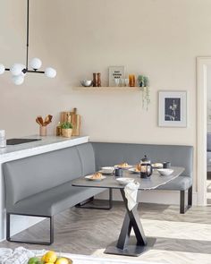 a corner table with two benches in front of it and some fruit on the counter