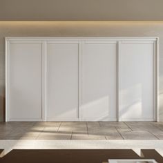 an empty room with three white doors on the wall