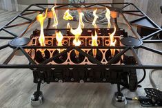 a fire pit sitting on top of a hard wood floor next to a metal frame