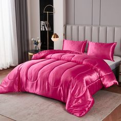 a bright pink comforter and pillows in a bedroom